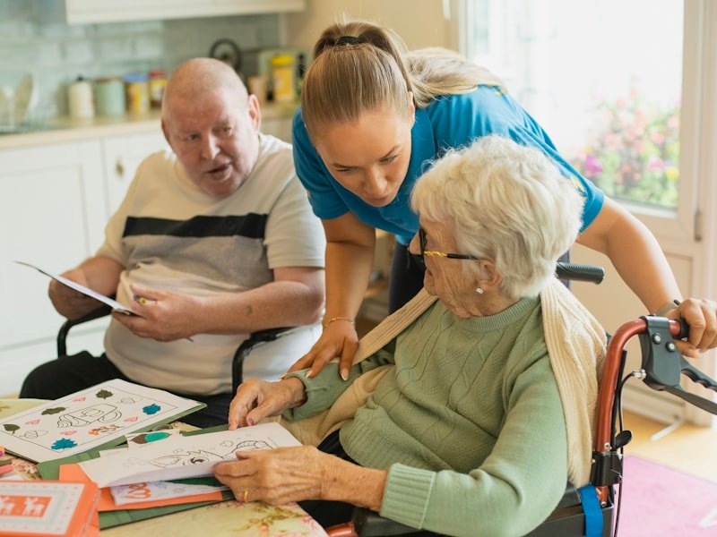A caregiver guiding a senior through a gentle colouring activity