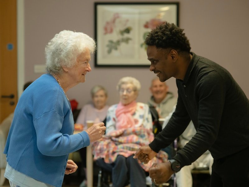 A caregiver and a senior sharing a joyful dance moment